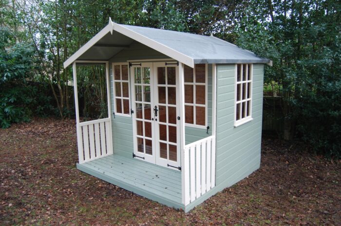 Small garden shed with double doors, white trim, and a green wooden exterior.